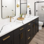 A striking modern bathroom featuring a long, dark double vanity topped with white quartz with dramatic black veining, and accented with black-framed mirrors and brushed brass fixtures, part of a lower level remodel in Edina, MN.