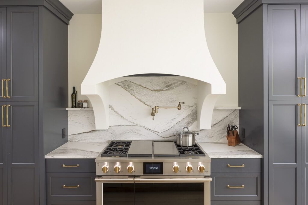 AMEK Inver Grove Heights kitchen remodel with professional level appliances, Cambria backsplash, and custom plaster range hood.