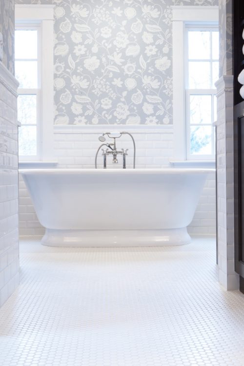 Elegant master bathroom featuring a freestanding white bathtub set against a patterned wallpaper accent wall, part of a whole home remodel in Wayzata, MN.