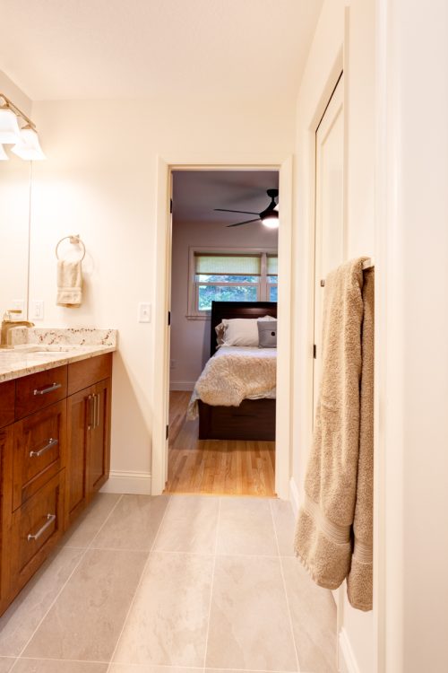 Contemporary bathroom with a long medium wood vanity and a view into the master bedroom, part of a remodel in Minnetonka, MN.